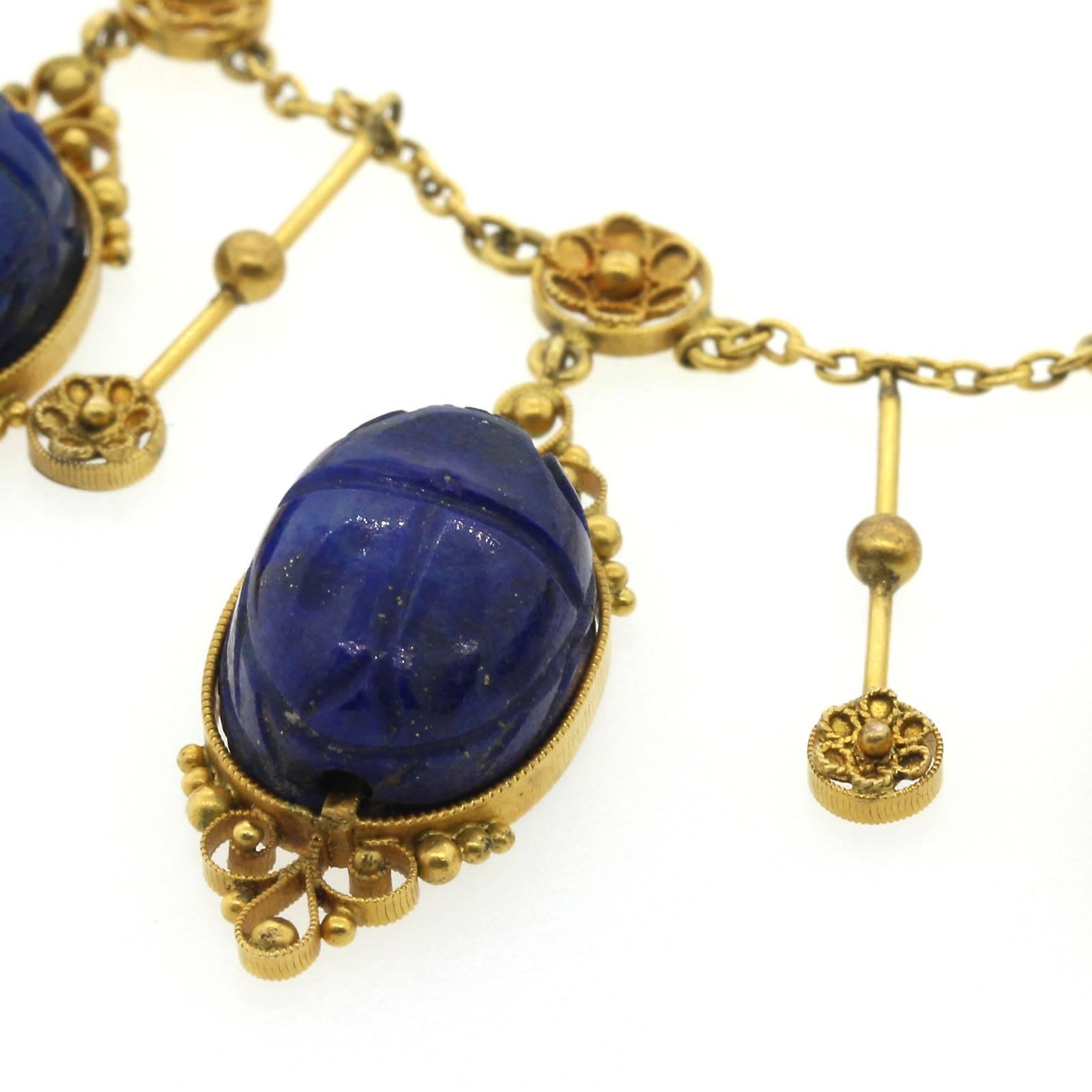 Awe inspiring Egyptian Revival  hand carved Lapis Lazuli scarab necklace.  The necklace is created with nine scarabs each hand carved on the top and each back is perfectly detailed with Egyptian hieroglyphic symbols that adds a surprising touch. 