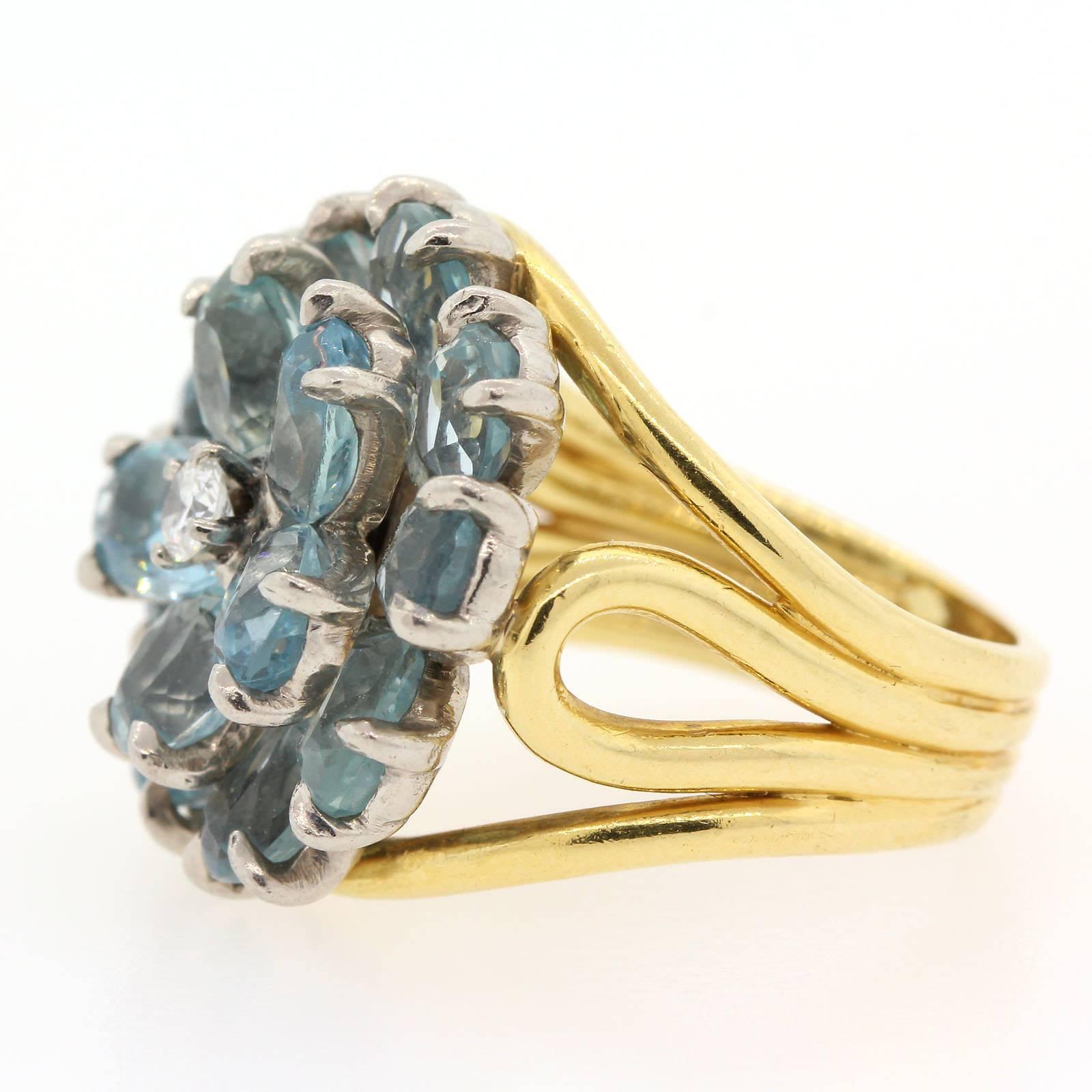 A vintage Tiffany & Co. oval cut Aquamarine flower ring.  A Round Brilliant cut diamond adds a special touch to this high design 18KT yellow gold ring.   Circa 1960s.