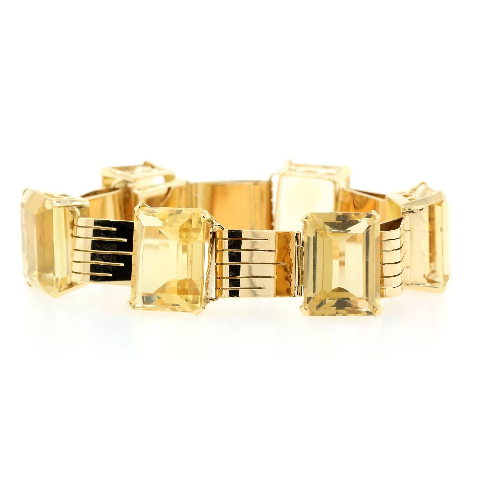 Classic Retro 18KT yellow gold bracelet featuring seven rectangular emerald cut Citrine quartz gems.  Each Citrine weighs approximately 20 carats, and is set in a detailed basket joined by a stylized articulated links. The bracelet is 7.00 inches