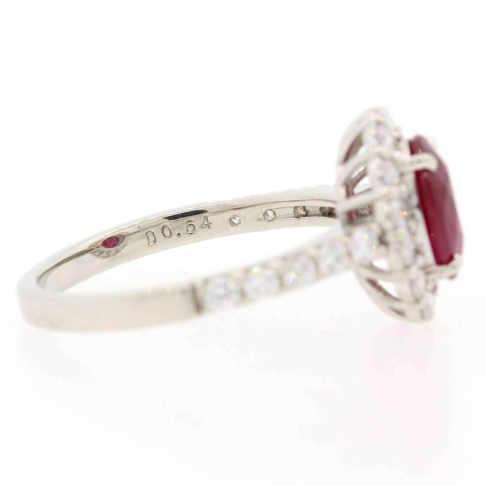 A perfect engagement ring!  Handmade platinum setting featuring an oval cut Burma Ruby weighing 1.68 carats, surrounded by fourteen Round Brilliant Cut Diamonds of H color - VS clarity.  The ring is accented on the sides by six Round Brilliant Cut