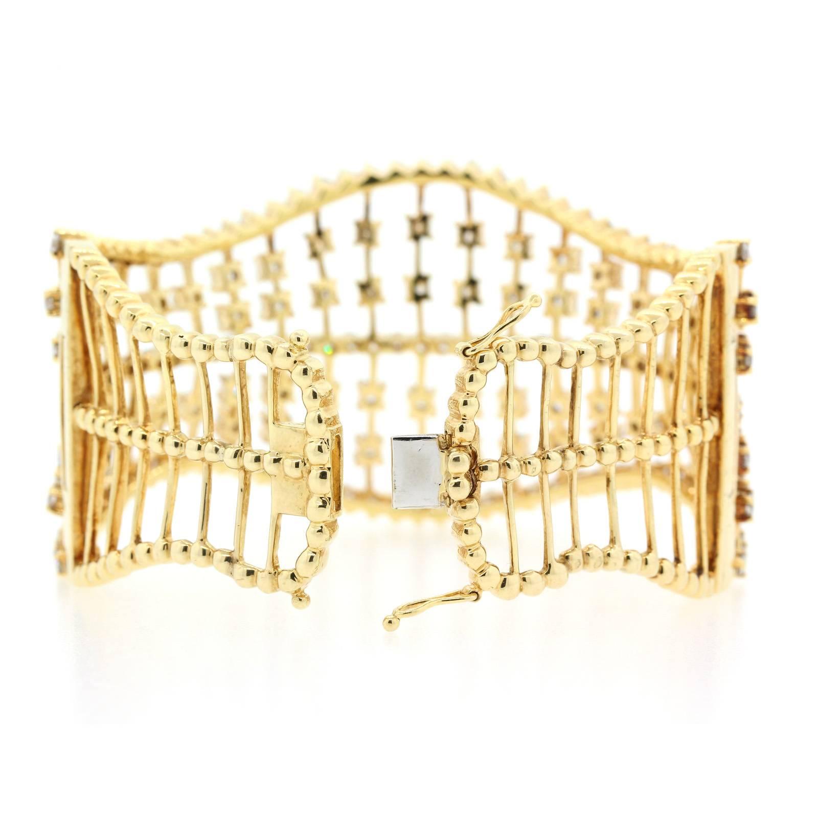 A fashionable 14KT yellow gold of open wire work and curvy lines cuff.   It is  beautifully set with 11.00 carat of Round Brilliant Cut Diamond of shimmering  H color - VS/SI clarity.  The bracelet fits a medium size wrist.  It is a bright bracelet