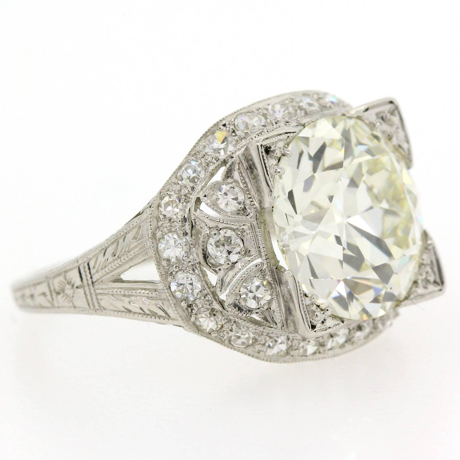 A gorgeous eye popping Art Deco ring featuring a super brilliant Old European Cut Diamond weighing 4.55 E.G.L. certified L color VS1 clarity.  This stunning platinum ring is hand engraved with delicate details and accented with old Single Cut