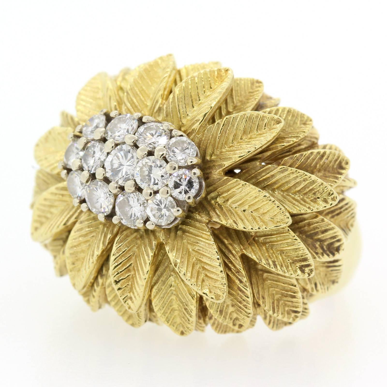 A 1960's 18KT yellow gold ring centering a cluster of thirteen Round Brilliant Cut Diamonds with cascading palm leaves.  Pretty!
