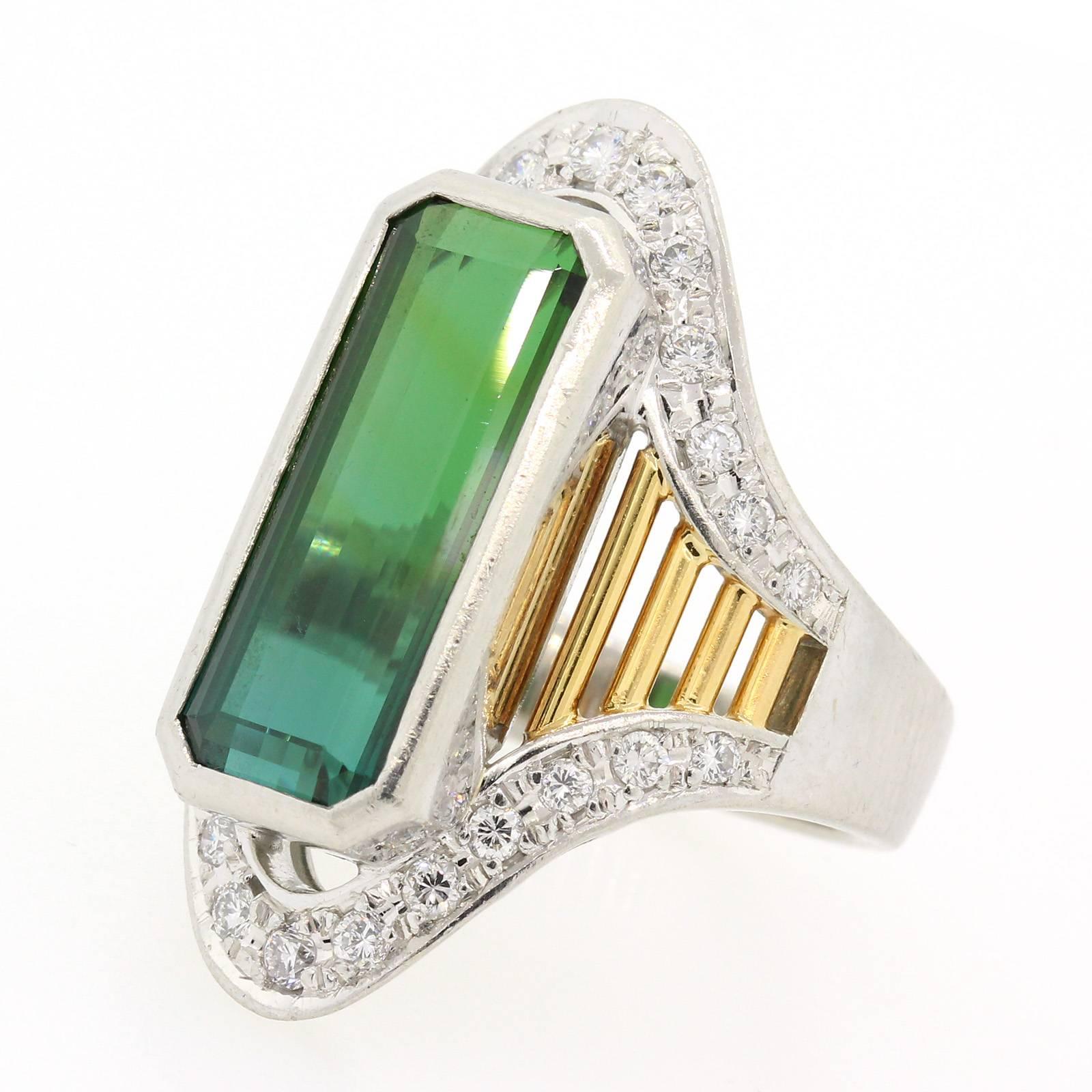 A stylish  platinum and 18KT yellow gold ring featuring an elongated 7.53 carat Green Tourmaline.   The ring is accented with Round Brilliant Cut Diamonds and enhanced with yellow gold open work. Impressive and Fun Ring!