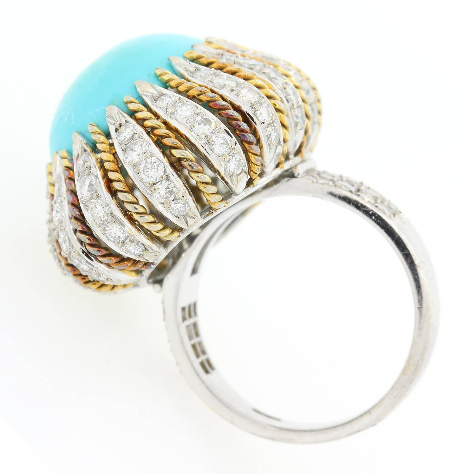 The bombay style ring features a 11.5 carat cabochon cut Turquoise.   The Turquoise is nestled among rising diamond and 18KT white gold flames, alternating with 18KT yellow gold ropes.  The Round Brilliant Cut Diamonds all weigh 2.07 carat, and are