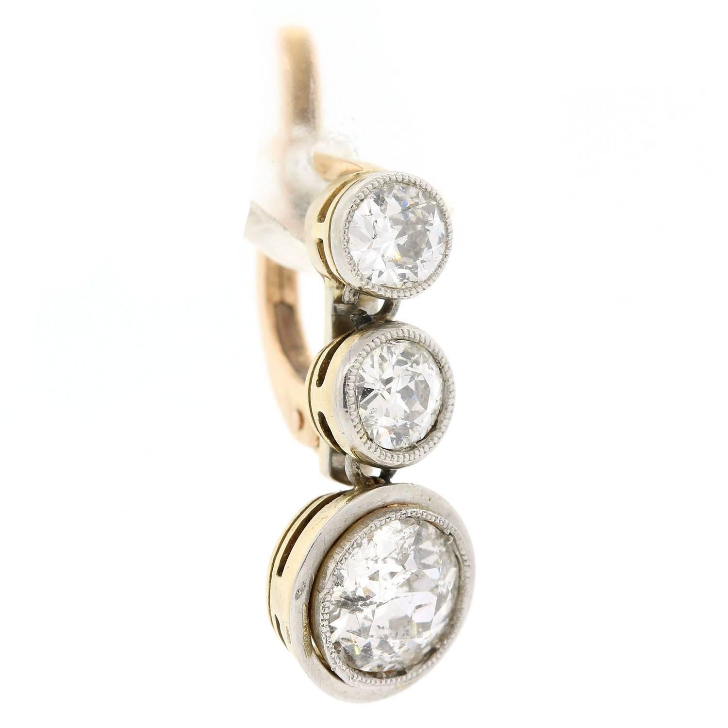 Practical luminosity!  These platinum topped and 18KT yellow gold earrings are bezel set with graduating Old European Cut Diamonds.  The larger bottom diamonds both weigh 1.85 carats , the total diamond weigh is 2.95 carats.  All diamonds are of H/I
