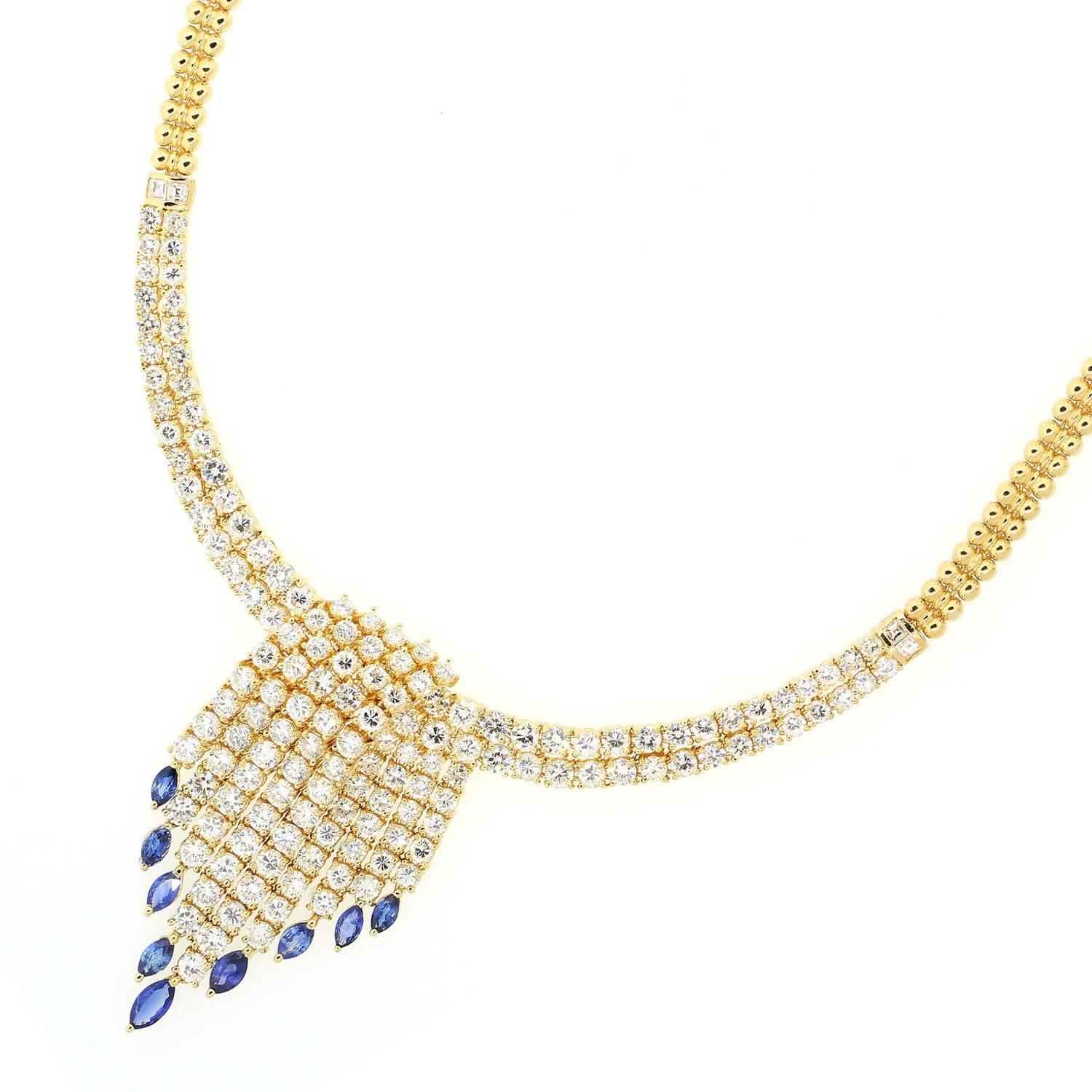 A tassel design 18KT yellow gold necklace with 16.95 carats of sparkly Round Brilliant Cut Diamonds.  This unique necklace features cascading Diamonds dropping  3.05 carats of Blue Sapphires.  The necklace has a 