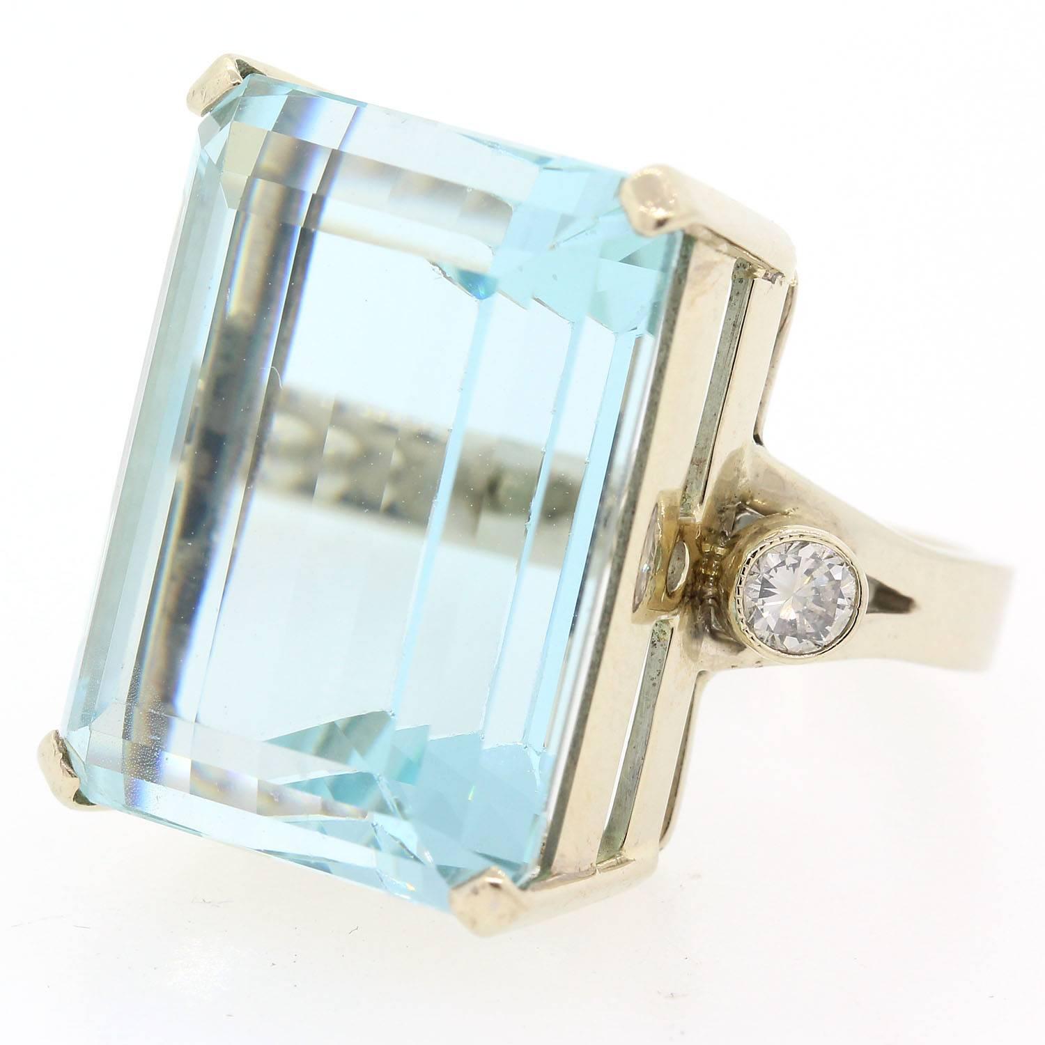 Elegant simplicity.  This beautiful 25 carat Emerald Cut Aquamarine is nested in a 14KT white gold setting.   Two Round Brilliant Cut Diamonds enhance the sides of the ring.  Circa 1960s