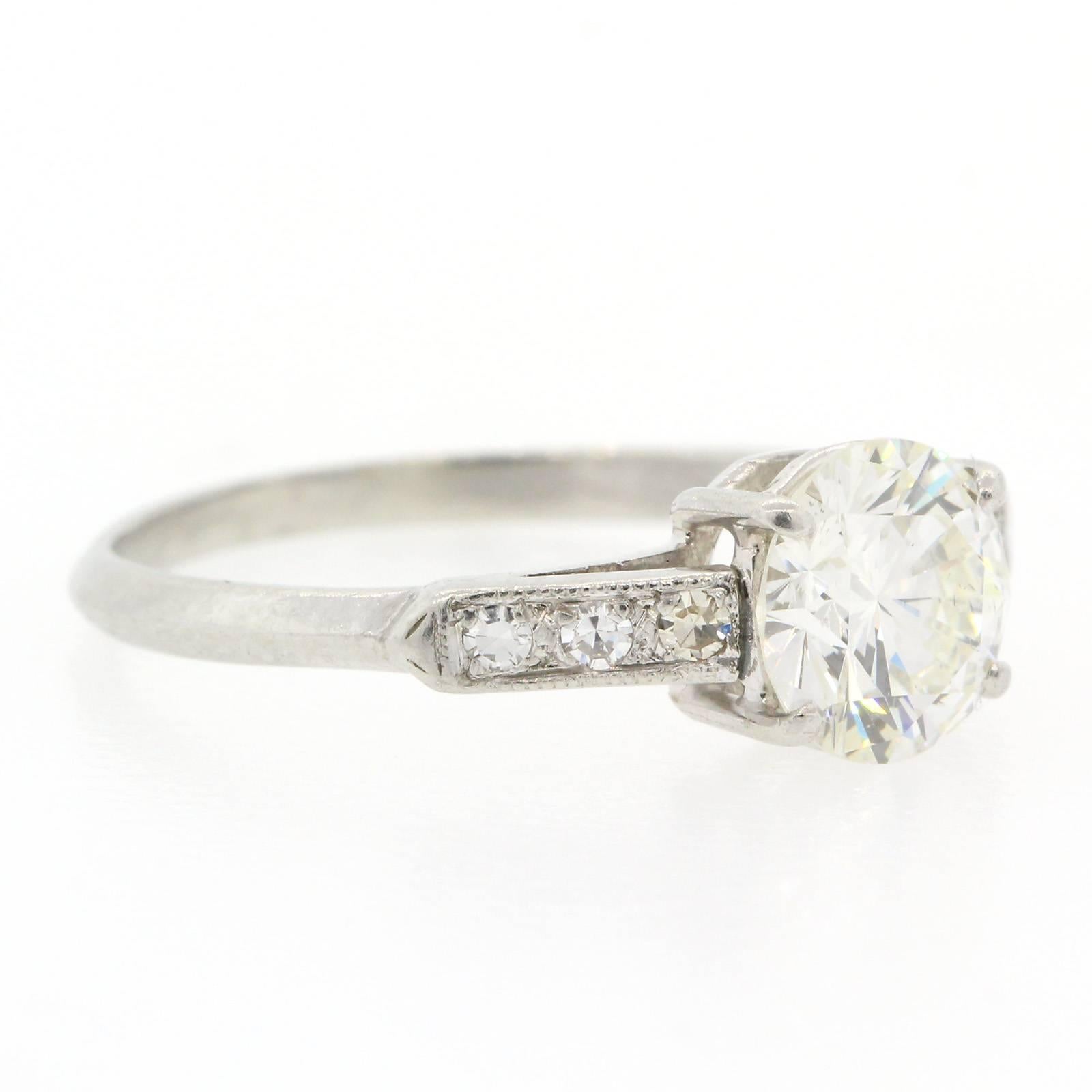 The Classic Engagement Ring!  A beautiful 1940s platinum ring featuring a 1.11 carats Round Brilliant Cut Diamond, certified I color - VS2 clarity and flanked by six old Single Cut Diamonds.  The setting is enhanced with time worn milgrain.  Just