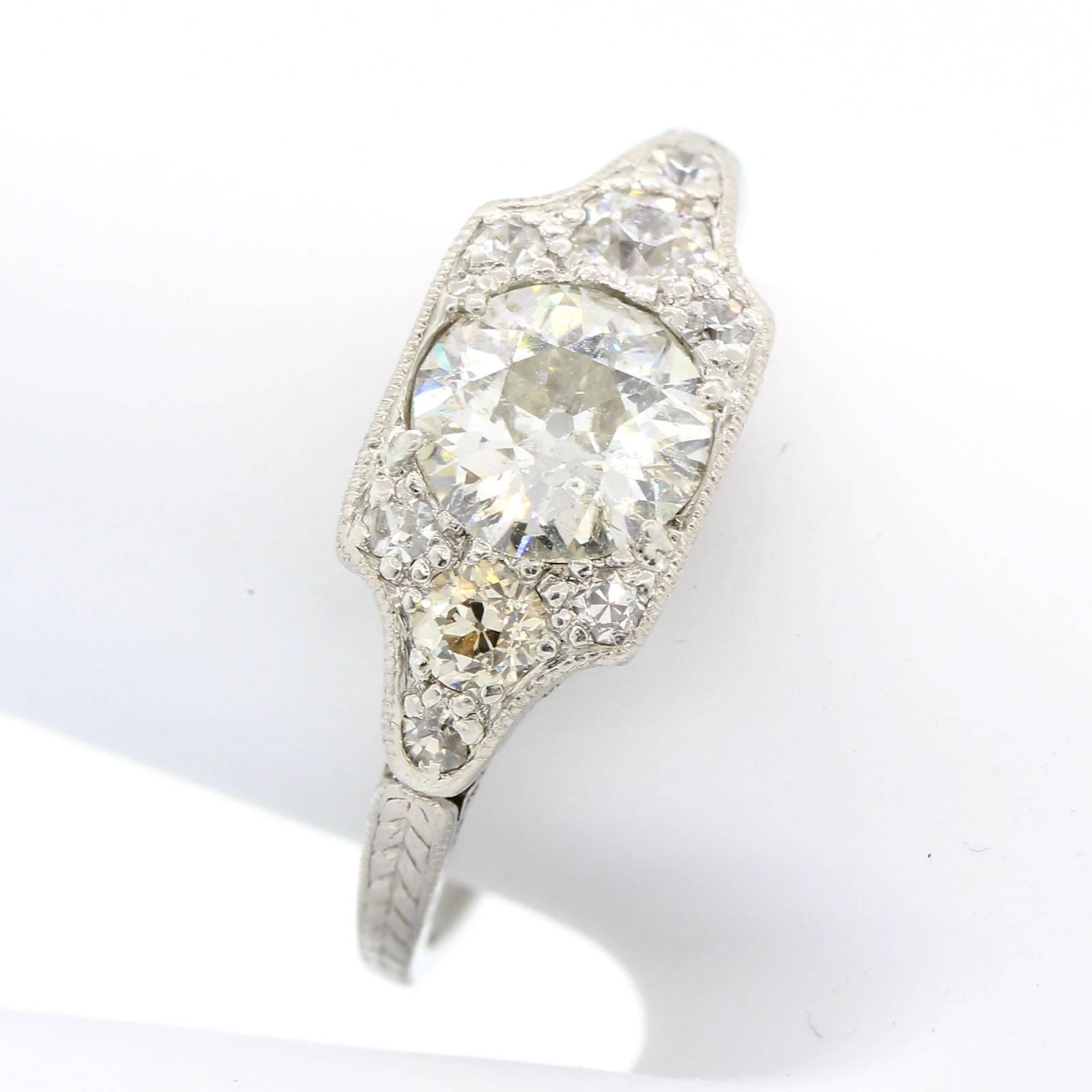 Coveted 1930's diamond and platinum ring.  The all engraved setting features a 0.93 carat Old European Cut Diamond of I/J color - SI3 clarity, flanked by two Old European Cut Diamonds.  Accenting the ring are six old Single Cut Diamonds.  All