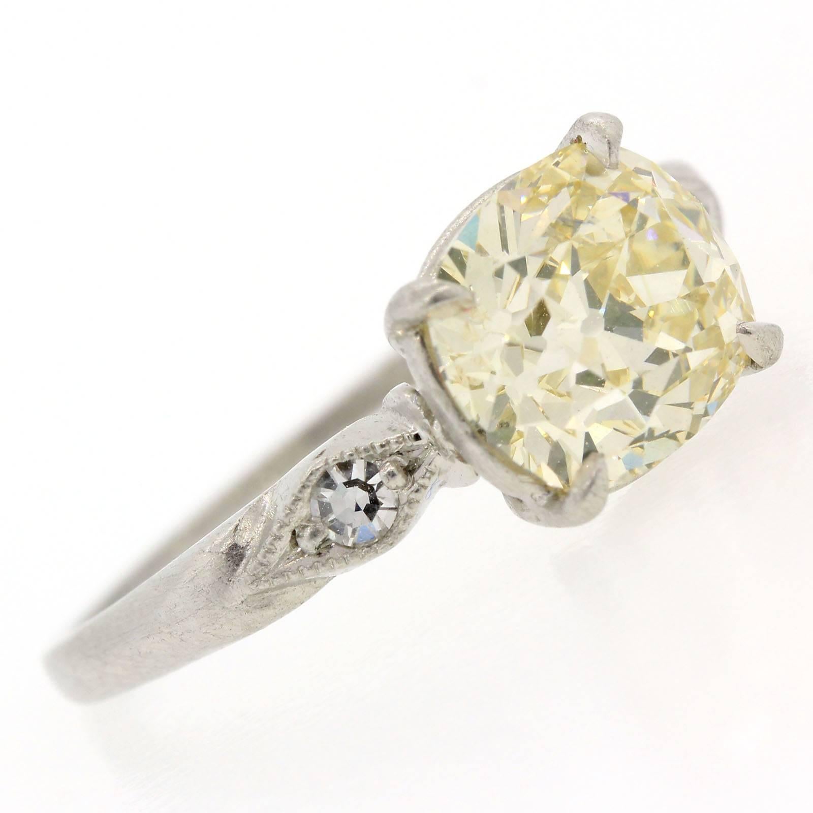 A beautiful engagement ring from the 1940s, this platinum ring features a 2.25 Old Mine Cushion Cut Diamond.  The diamond is certified of warm Q color - SI clarity and is flanked by two old Single Cut Diamonds.   A gorgeous ring!