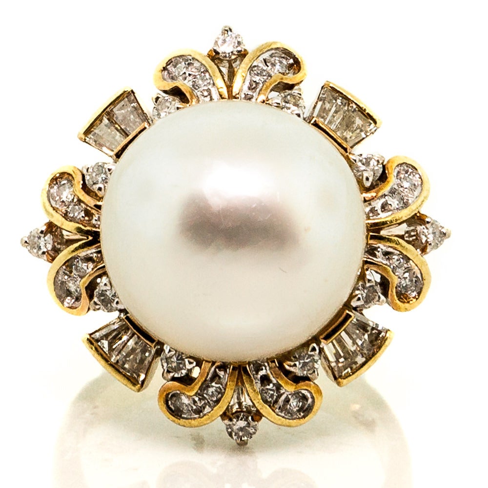 Cocktail Gold ring is a beautiful Vintage piece (circa 1970s). The South Sea White Pearl, sized at 19 mm and set in 18 KT Yellow Gold, is accompanied by approximately 0.65 cts. of Round Brilliant Baguette Cut Diamonds. Characteristic to the
