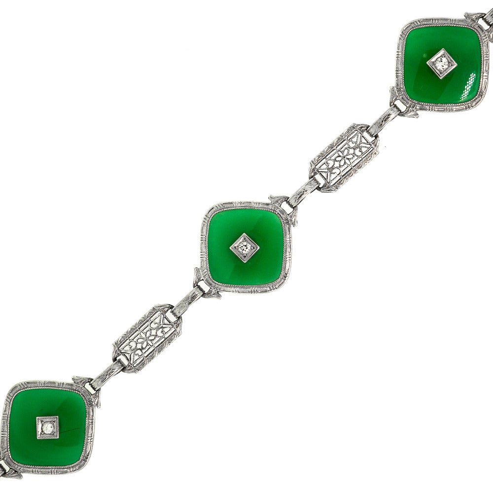 Romantically designed filigree 14 KT White Gold Bracelet is a majestic 1930’s era bezel style bracelet featuring the highest quality gems. Central to the bracelet are three Cushion Chrysoprase plaques, each accented by one Old European Cut Diamond.