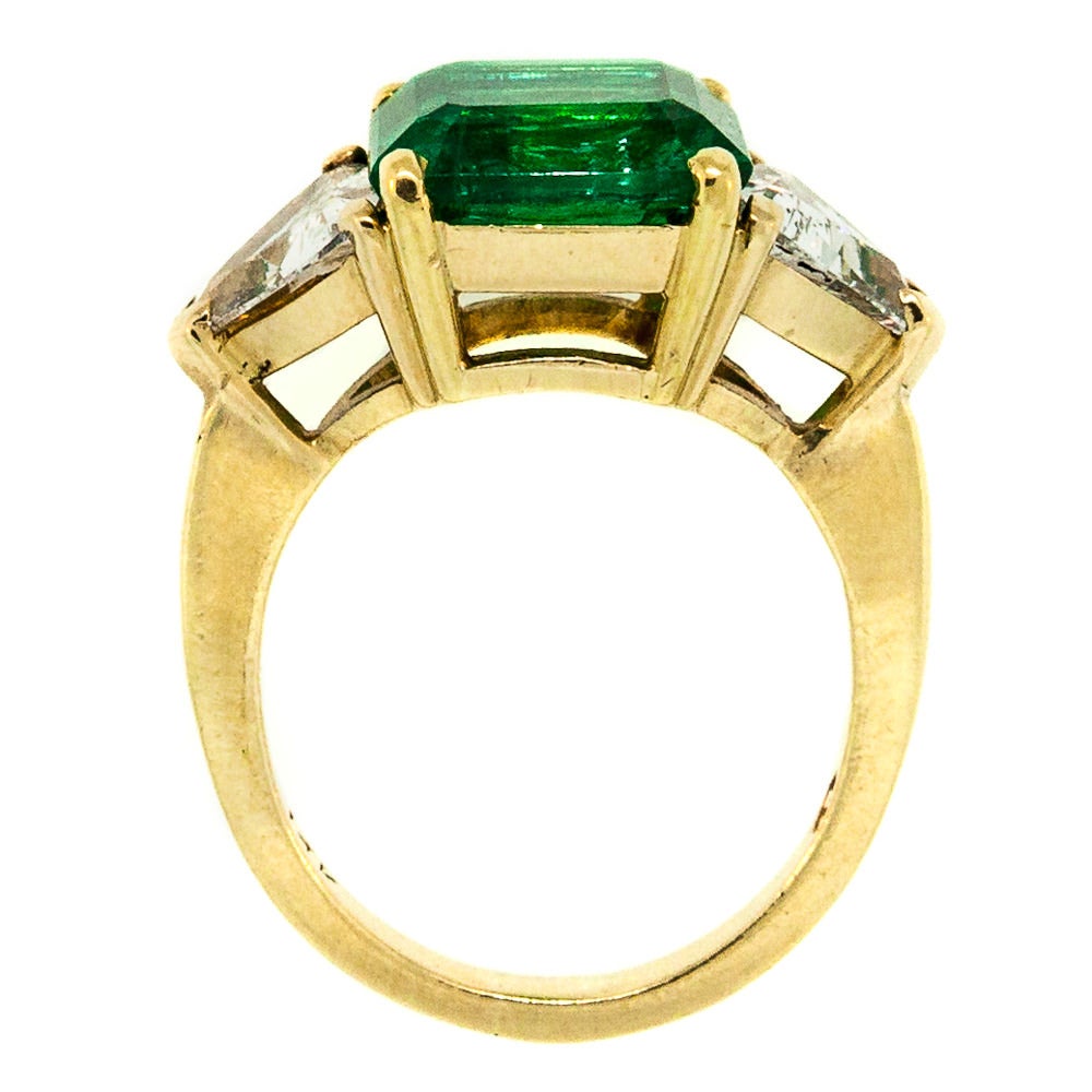 This beautiful, eye popping ring features a massive 4.04 carats Colombian Emerald, American Gemological Lab certified and  flanked on each side by Triangle Cut Diamonds. The stones are set in a 14KT yellow gold. The Perfect Anniversary Gift!

SKU: