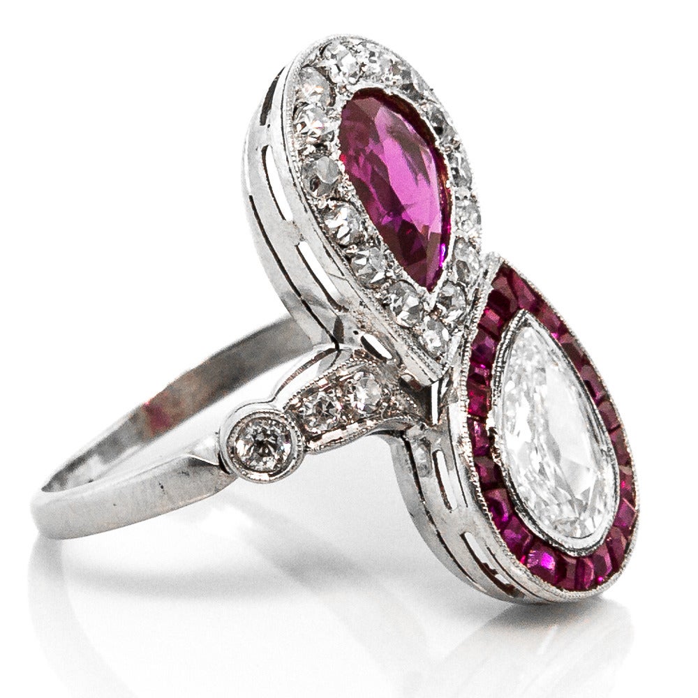 Glistening from every angle, this ring features an impressive medley of Diamonds and Rubies. Authentic to the 1940s Vintage era, this stylish ring is made from Platinum and set with a Pear Shaped 1.38 cts. Burma Ruby and 1.05 cts. Old Cut Diamond,