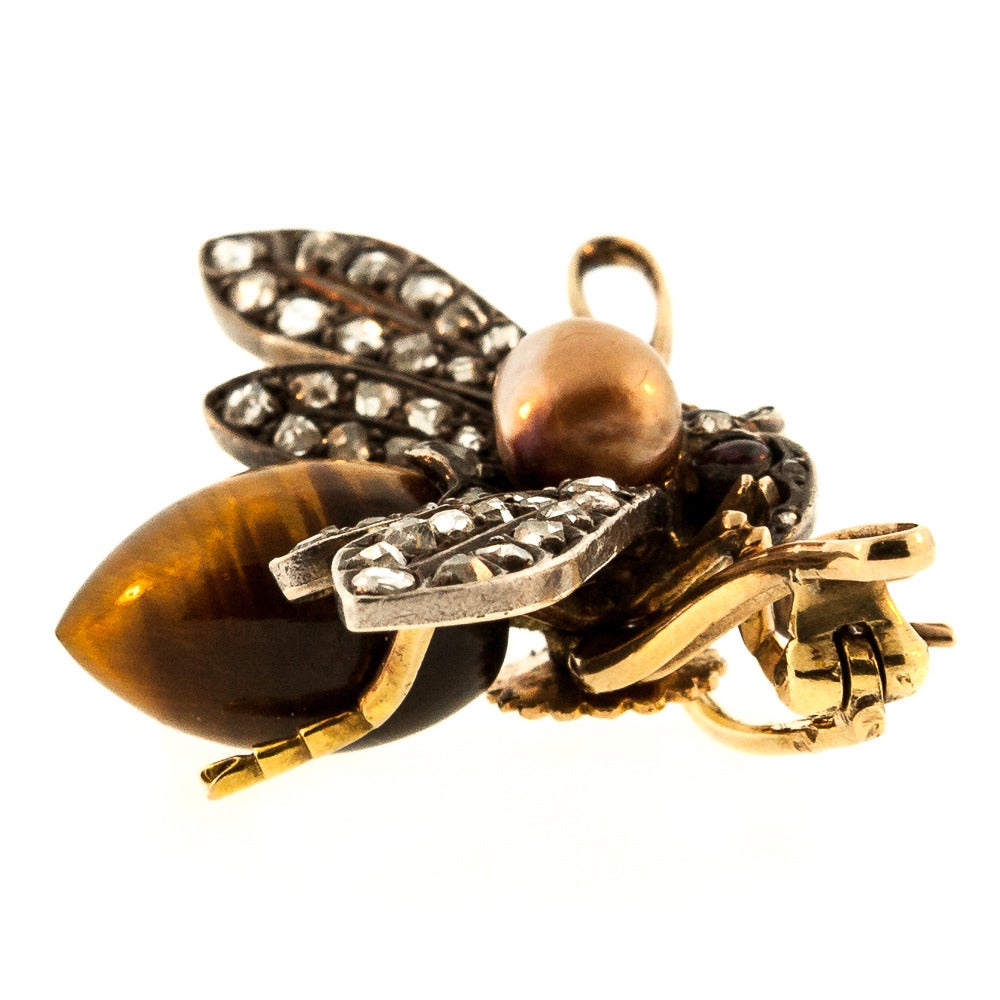 From the Victorian era this exquisite Tiger Eye and natural Pearl Fly Brooch.  The piece is hand made in France of 18 KT yellow gold and Sterling Silver. The wings are accented with fifty two Rose Cut Diamonds. weighing a total of 1.20 carats,  and