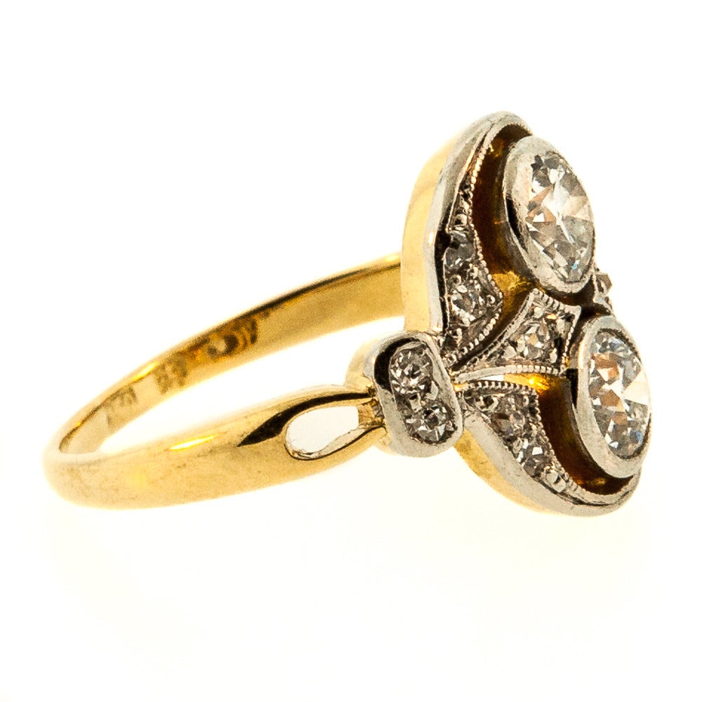 Handcrafted with love, this antique ring features two bezel set Old European Cut Diamonds (H/I color – SI1 clarity.) The perfection of the Diamonds is highlighted by each and every illuminating attribute of the piece. The Platinum topped 18 KT