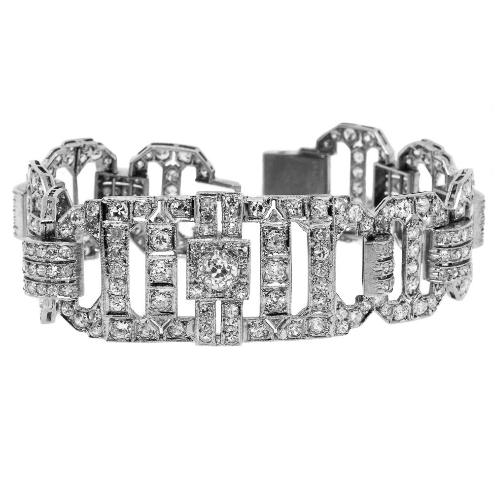 Splendid 1940’s wide platinum bracelet set with Old European and Single Cut Diamonds. The bracelet features a long cushion shape center plaque, and is completed on each side with four open cut corner rectangular links. All diamonds are evaluated as
