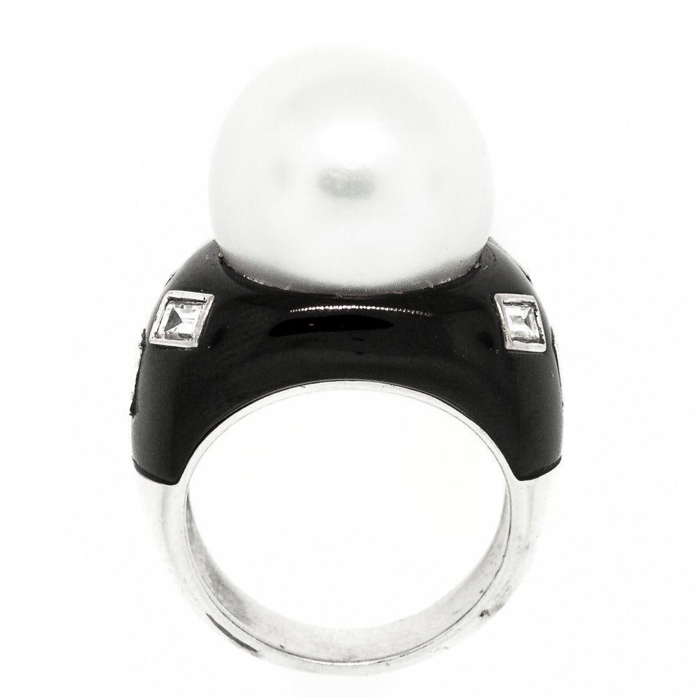 Eye popping contemporary 18KT white gold and black enamel ring featuring a 13.86 mm beautiful large white Pearl. The  setting is accented with six bezel set Baguette cut diamonds all weighing 0.55 carat of H color - VS1/VS clarity.  The statement