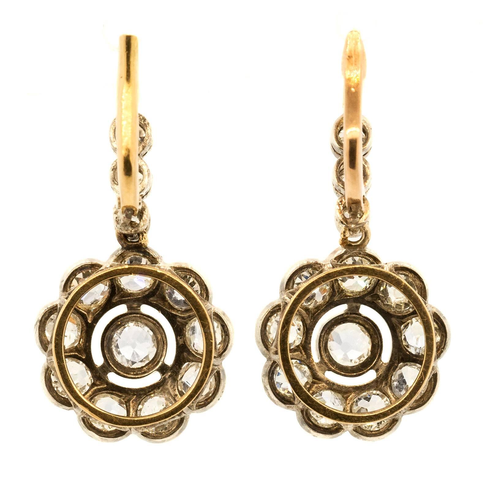 Classic and beautiful Silver 18KT yellow gold dangling earrings with over 5.70 carats of Old Cut Diamonds. The scalloped borders beautifully accent these  Circa 1910 special earrings.

