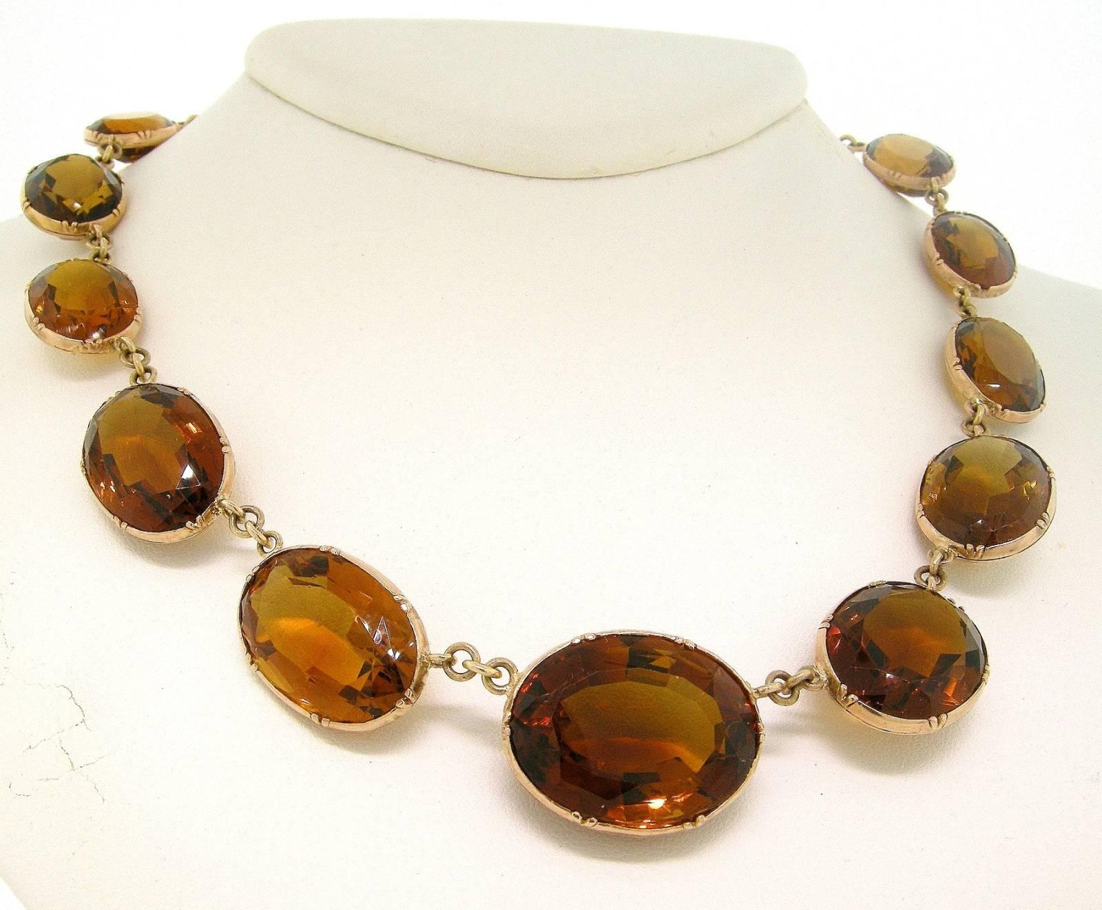 Madeira Citrine Gold Necklace from the Victorian Period is composed of sixteen graduated oval cut Madeira Citrine stones bezel set in 14KT yellow gold with a fork like clasp.

SKU:  N335