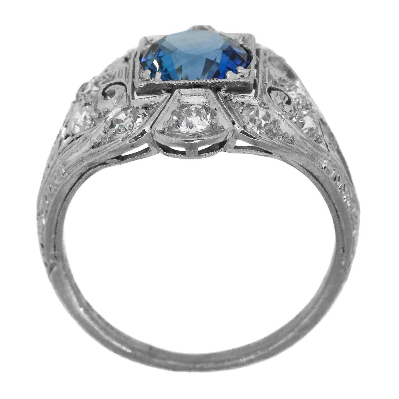 Art-Déco-Ring aus Platin mit einem Ceylon-Saphir:: umgeben von zwölf Diamanten im Altschliff:: bewertet als Farbe I/J - Reinheit VS/SI:: in einer schönen Platinfassung mit Wirbelmuster und Filigranität:: verziert mit einer Gravur 