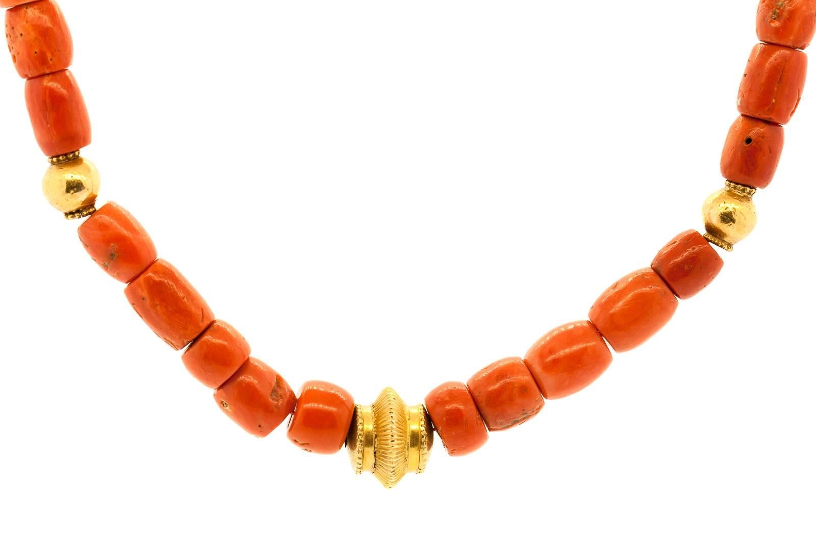 This organic necklace has been created with forty three vintage barrel shape Tibetan Coral beads and accented with four interspersed 20KT yellow gold barrel beads.  The necklace measures 22 inches long. Coral beads are circa 1940's.