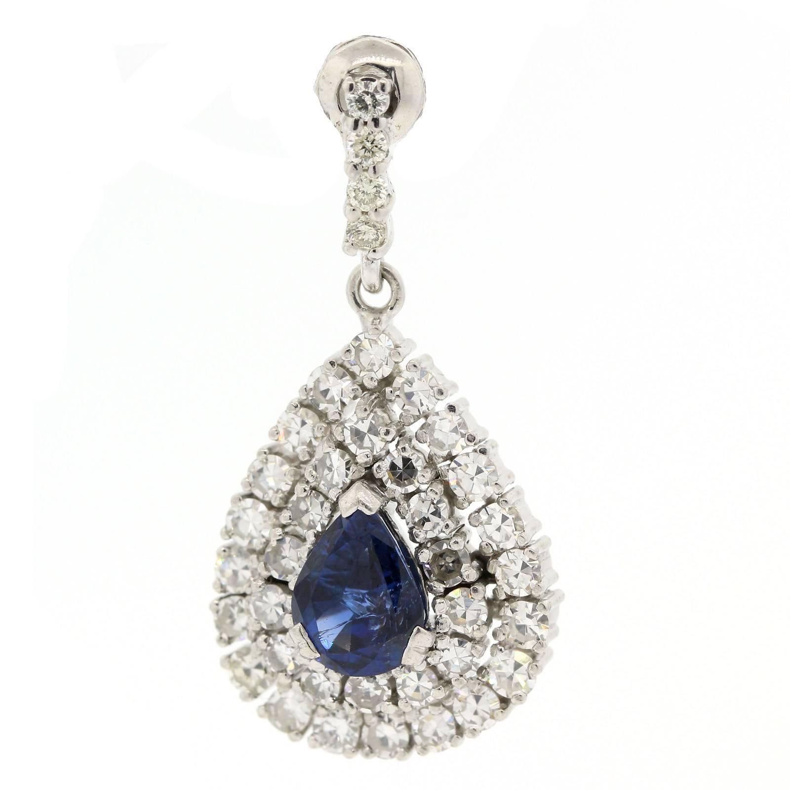 Brilliant contemporary Sapphire and diamond drop earrings,  The 18KT white gold earrings each feature a 1.33 carat Pear Shape blue Sapphire surrounded by two rows of diamonds and dangling from a diamond bar.  All diamonds total approximately 2.60