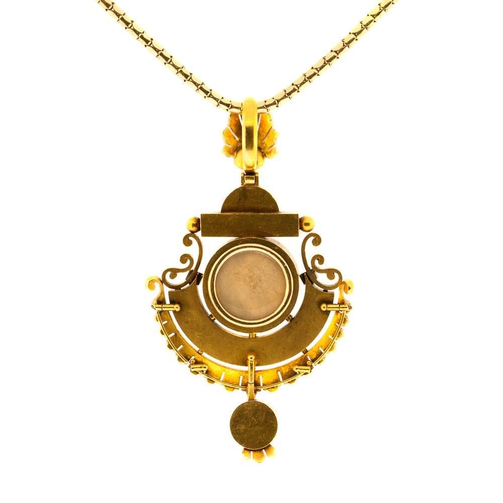 15KT yellow pendant-locket centering a 10.55 mm natural white pearl and twenty three smaller natural pearls. The pendant is accented with light blue enamel, and the back of the pendant is a locket to hold a special memento. Circa 1890. How Very