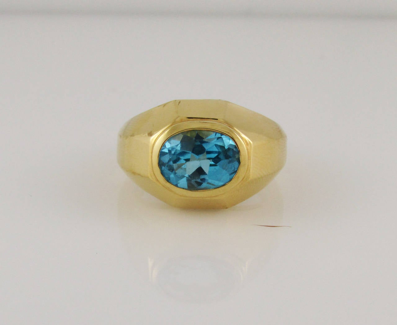 18KT yellow gold and blue topaz ring designed as as a faceted domed mounting set at center with a faceted oval blue topaz. Finger size 7.  Signed Bvlgari.