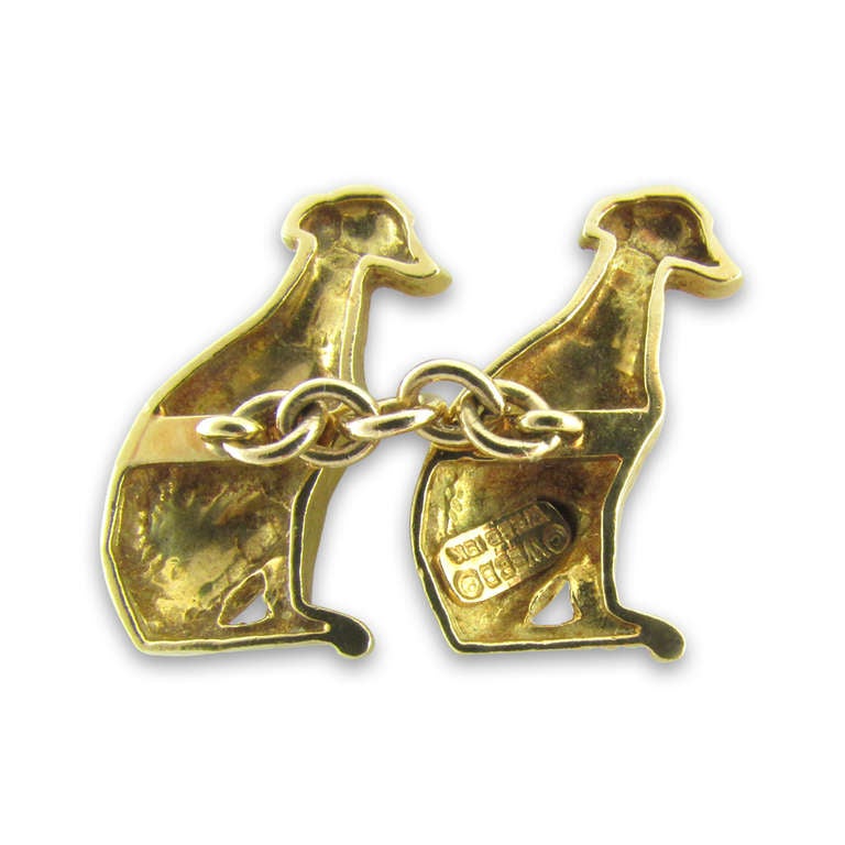 18KT yellow gold seated dog cufflinks with a chain connector. Signed Webb for David Webb.