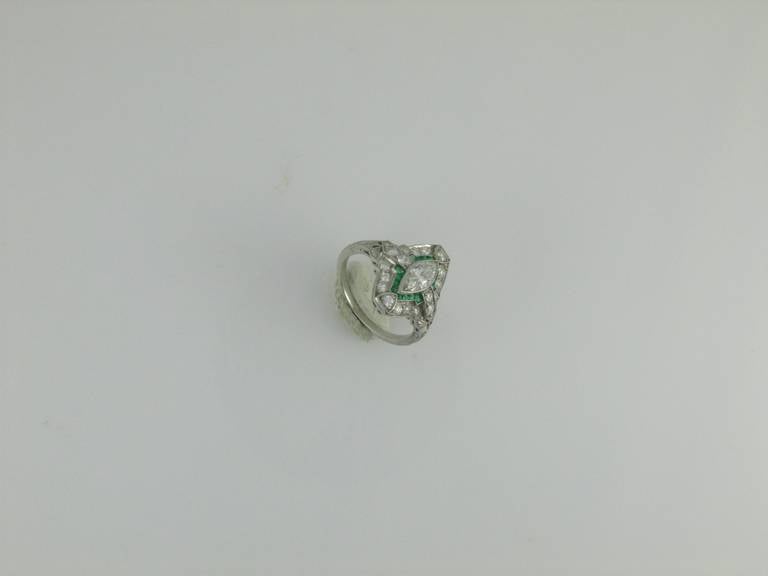 Art Deco platinum, diamond and emerald ring with a marquise diamond at the center weighing approximately 0.50cts.  Size 4.5.