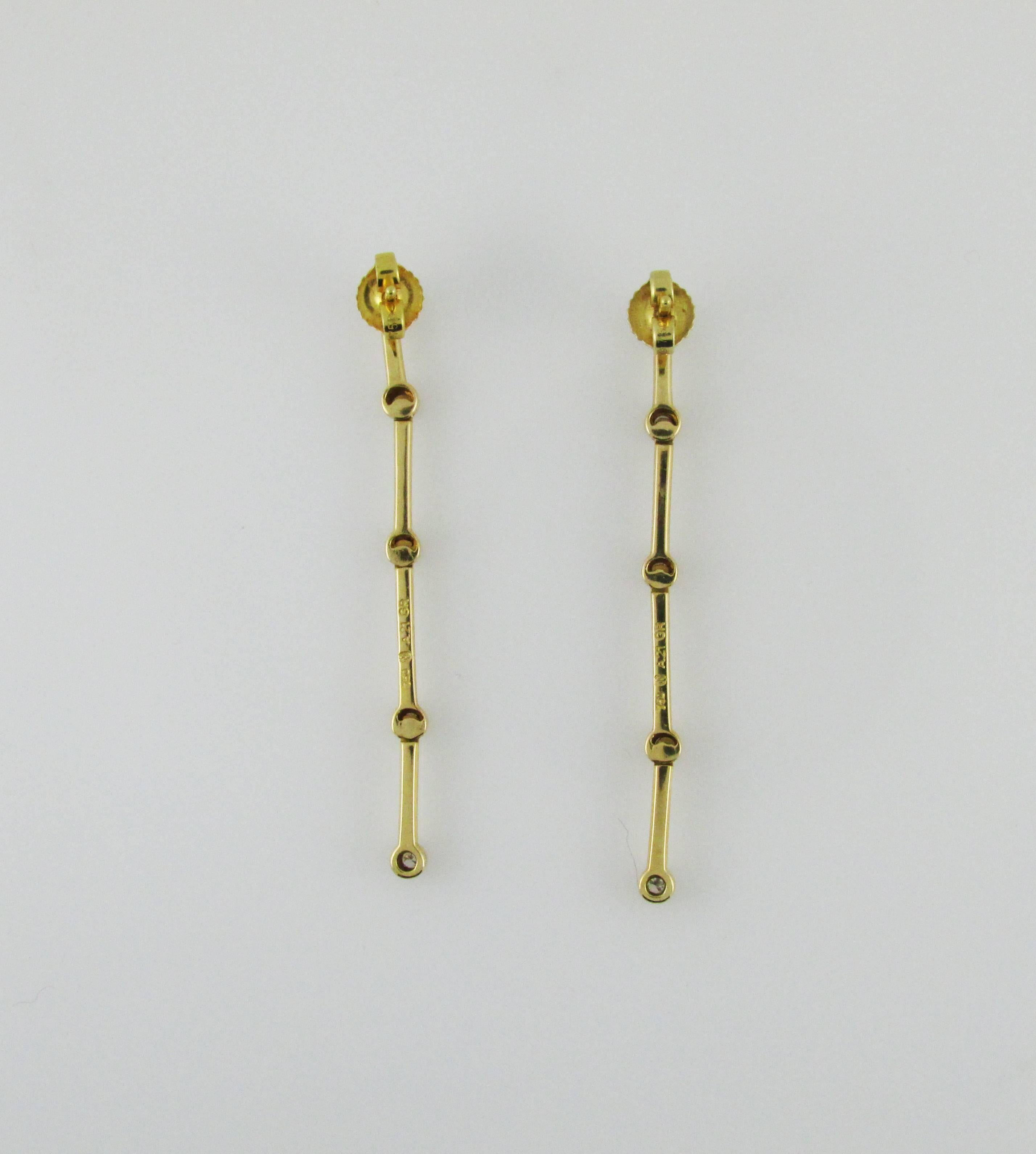 18KT yellow gold and diamond drop earrings. Each earring is bezel set with 5 round diamonds. Post backs. Signed Ilias Lalaounis Greece. 2 inches long.
