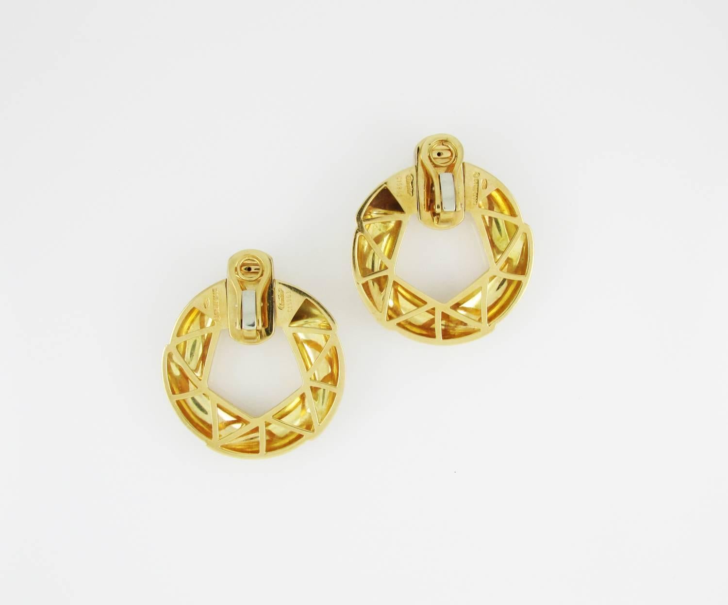 18KT polished yellow gold door knocker earrings. Signed Cartier, c1993, and numbered. Clip backs, no posts. 1.5 inches long, 1.25 inches wide.