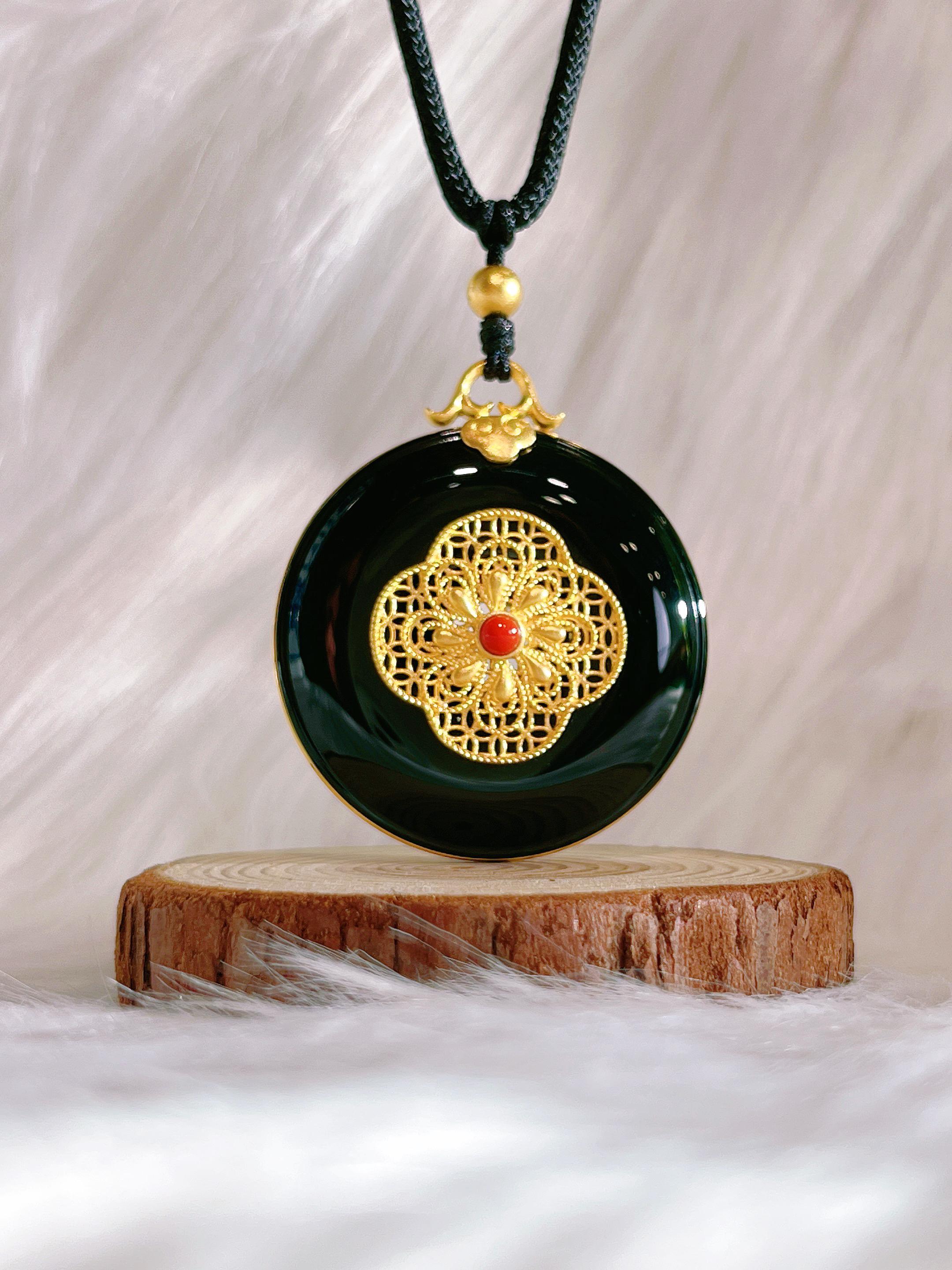 Ce collier exquis combine harmonieusement l'or 24 carats à motifs symétriques et le jade Hetian (néphrite naturelle), employant des techniques impériales de filigrane pour atteindre une extraordinaire délicatesse. Le jade noir d'encre dégage un
