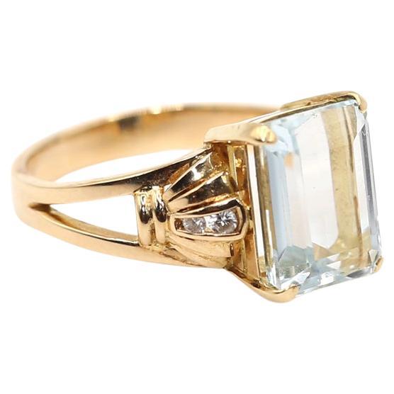 Aquamarine Diamonds Ring. An essence of elegance, beautifully light blue colored Aquamarine, emerald-cut  as a centerpiece, held by the fan shaped lugs on both sides with tiny yet fine Diamonds, round brilliant cut Diamond accents. 14 Karat Yellow