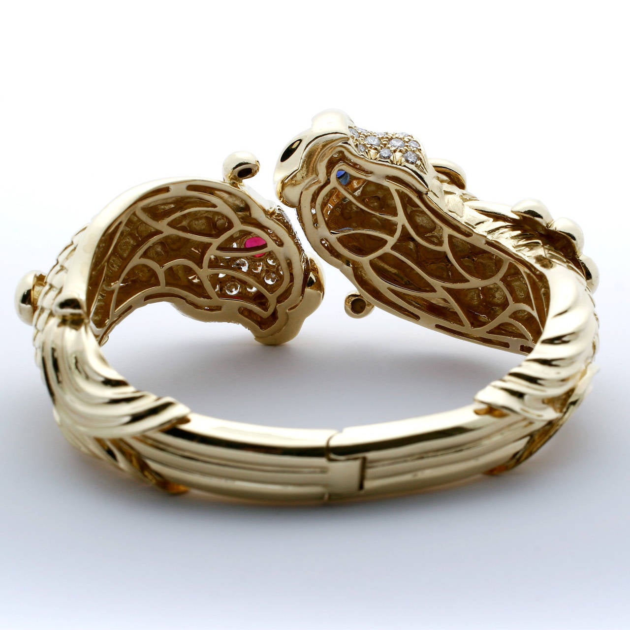 Vintage, Chunky, 18k Yellow Gold Koi Diamond Bangle Bracelet with 70 colorless diamonds weighing 2.60ctw (I/VS) 1 Ruby Eye weighing 0.64ct, and 1 Sapphire Eye weighing 0.62ct. Total Bangle weight is 98.5 grams. Marvelous.
Signed J.Cooper