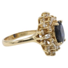 Anillo de cóctel abovedado de oro amarillo de 14 quilates con zafiro azul oscuro natural y halo de diamantes