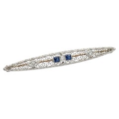 Spilla a barra in platino e oro antico con diamanti naturali e zaffiro blu, in stile filigrana