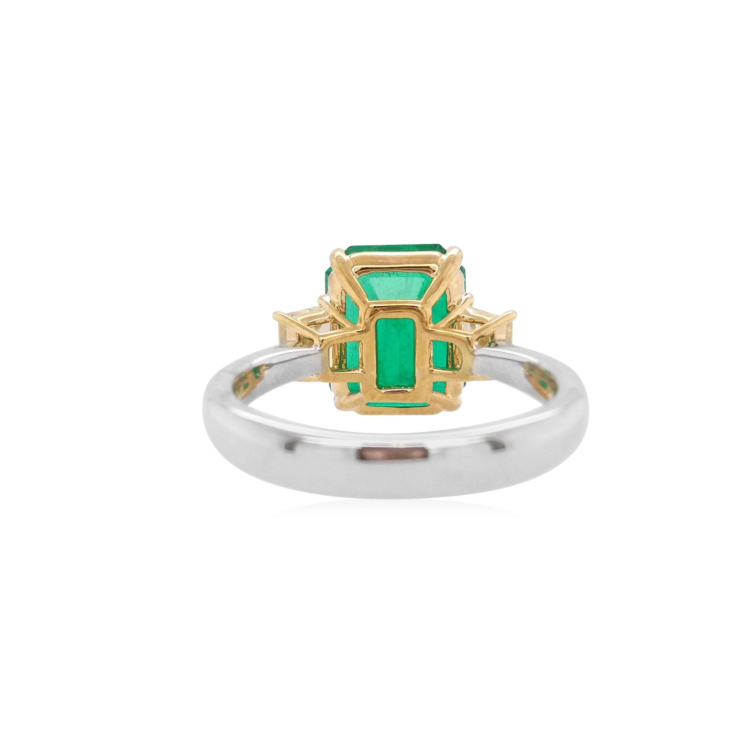 Cette magnifique bague en émeraude de Colombie présente une gemme d'un vert éclatant provenant de la mine colombienne de Muzo et d'une clarté exceptionnelle. Elle est rehaussée d'un élégant anneau en or et de diamants jaunes, alliant un design