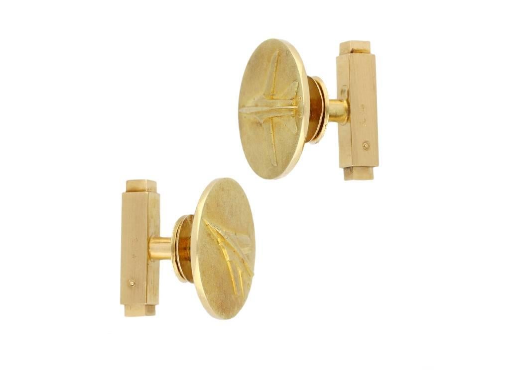 Cartier Mirage G8 cufflinks. A pair of yellow gold cufflinks, composed of a circular plaque with textured finish featuring an intricately raised plane motif on each alongside the inscription 'G 8', with smooth polished borders, fitted to the reverse