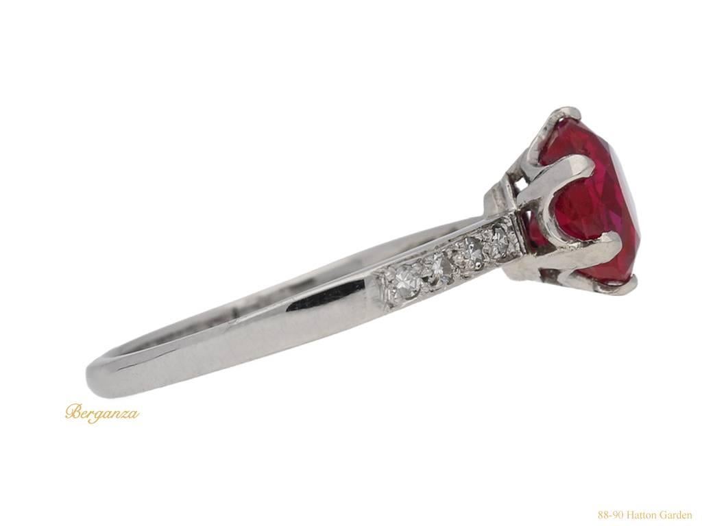 Burmese ruby and diamond ring. Set with a round old cut natural unenhanced Burmese ruby in an open back claw setting with an approximate weight of 1.92 carats, flanked by eight round single cut diamonds in open back grain settings with a combined