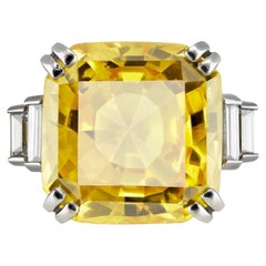Yellow Ceylon sapphire and diamond flanked solitaire ring, mid 20th Century.