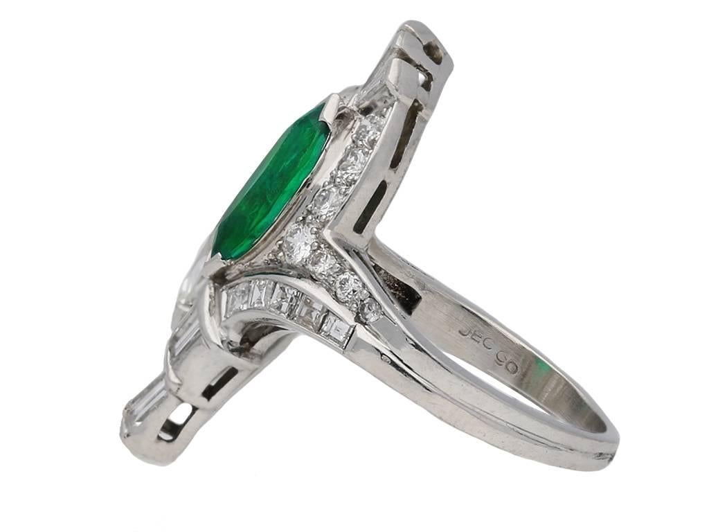 Emerald and diamond cocktail ring by J. E. Caldwell, American, circa 1940. A platinum ring diagonally set with one central marquise shaped old cut untreated Muzo emerald in a claw setting with an approximate weight of 0.90 carats, and one central