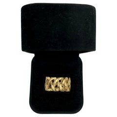 Anillo ancho tipo «cigar band» de oro amarillo de 14 quilates con el «nudo del amor eterno», siglo XX