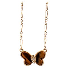 Vom Mid-Century-Stil inspirierte Halskette mit einem Anhänger in Form eines Schmetterlings aus Gelbgold und Tigerauge