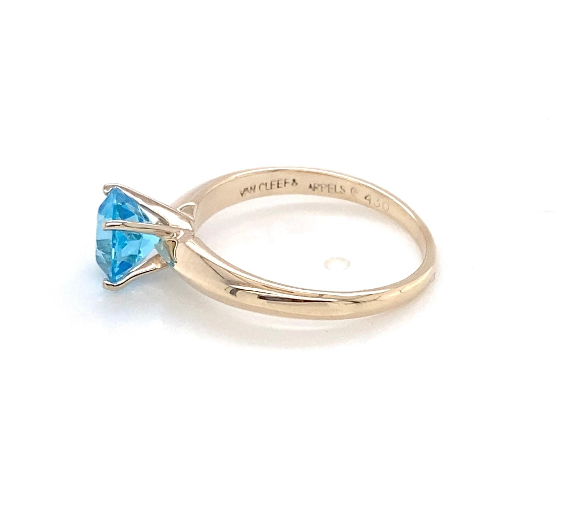 L'eleganza senza tempo incontra la vivacità dei colori in questo autentico anello solitario Van Cleef & Arpels, realizzato in oro giallo 14 carati. Al centro si trova un topazio blu svizzero rotondo splendidamente sfaccettato, del peso di 1,60