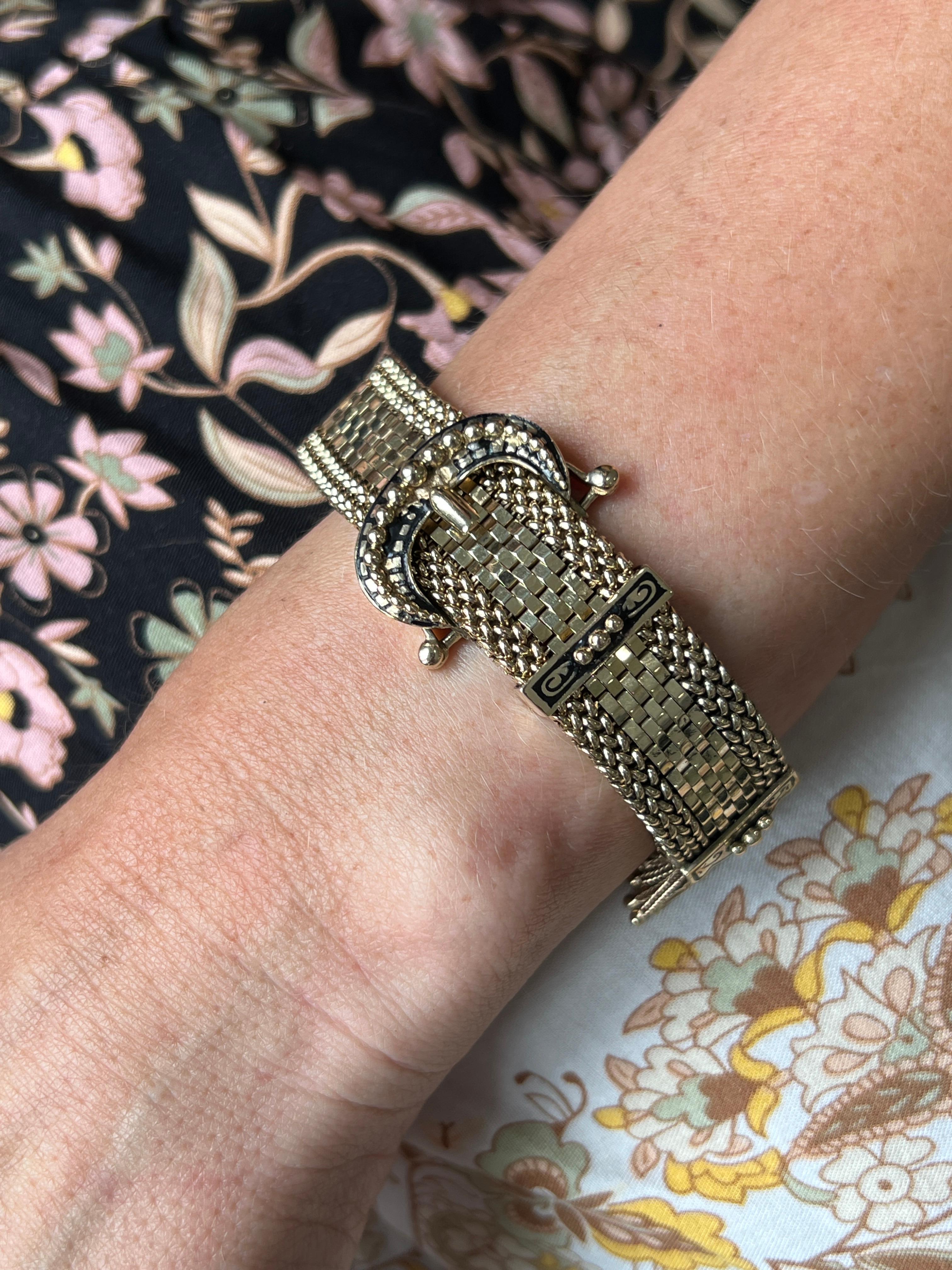 Ce bracelet vintage des années 1960 en or jaune 14 carats est une pièce intemporelle avec un design audacieux et distinctif de boucle de ceinture. Réalisé avec des détails de mailles complexes, le bracelet présente un motif de boucle proéminent de