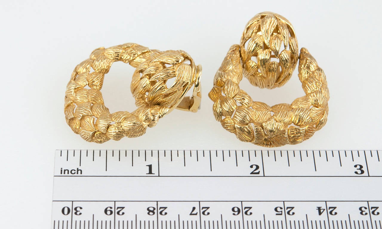 Very cool door knocker style clip-on earrings in textured 18 karat gold, circa 1970s.  These earrings measure approximately 1.35 inches in length, 1.18 inches in width, and 0.45 inches in depth.