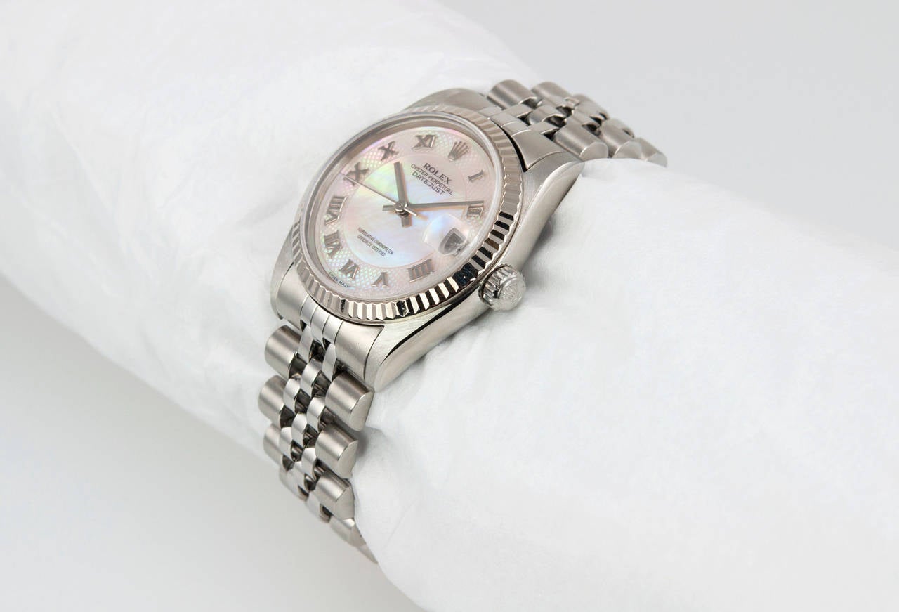 Rolex stainless steel mid-size Datejust wristwatch, Ref. 78274, 1999. This 31mm watch features a mother-of-pearl Roman numeral dial, an 18k white gold fluted bezel, sapphire crystal, locking waterproof crown, and stainless steel jubilee bracelet.